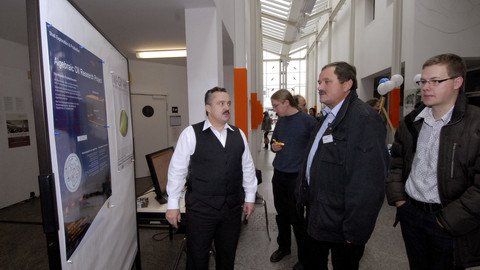 Prof. Kreuzer erklärt den Besuchern der Ausstellung das algebraic oil research project